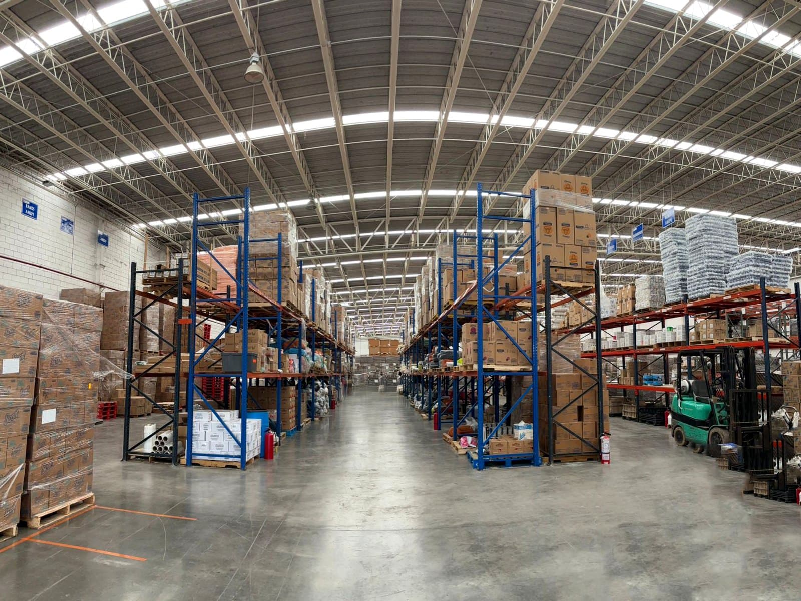 Pasillo principal del almacén Hi Supply con racks de inventario Tier 1